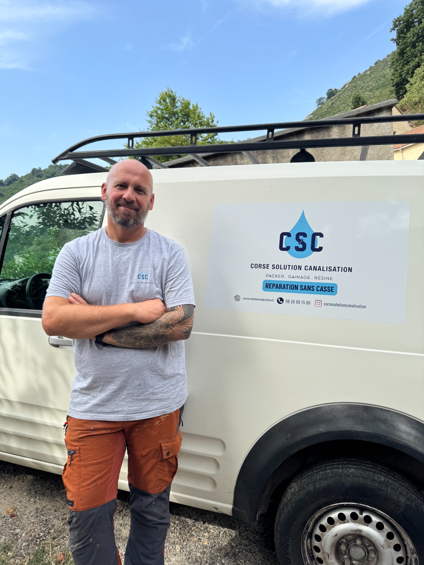 Homme aux bras croisés devant un camion blanc, avec panneau publicitaire “CSC” et slogan “Réparation sans casse”.